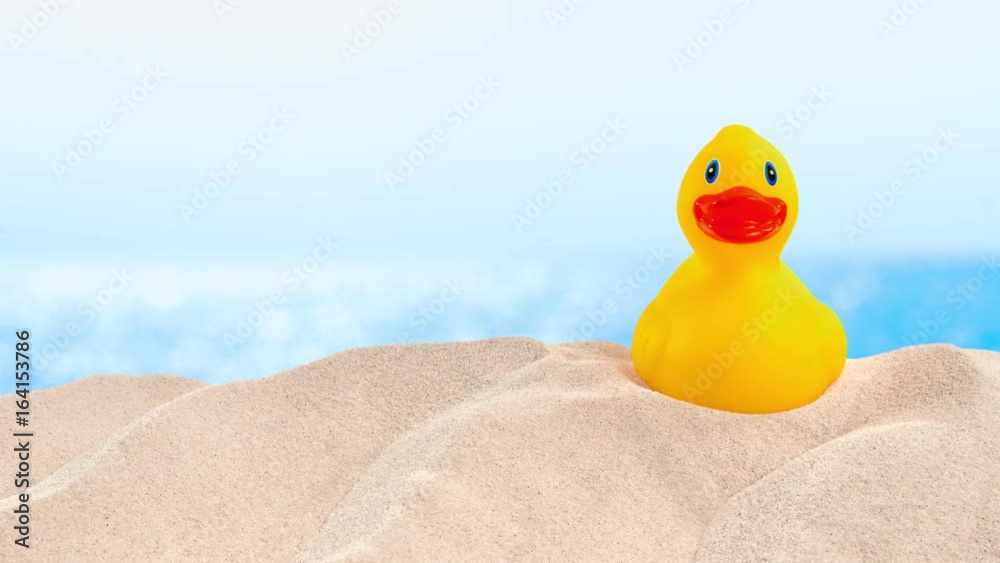 On the Beach - rubber duck on a sand dune in front of beautiful azure