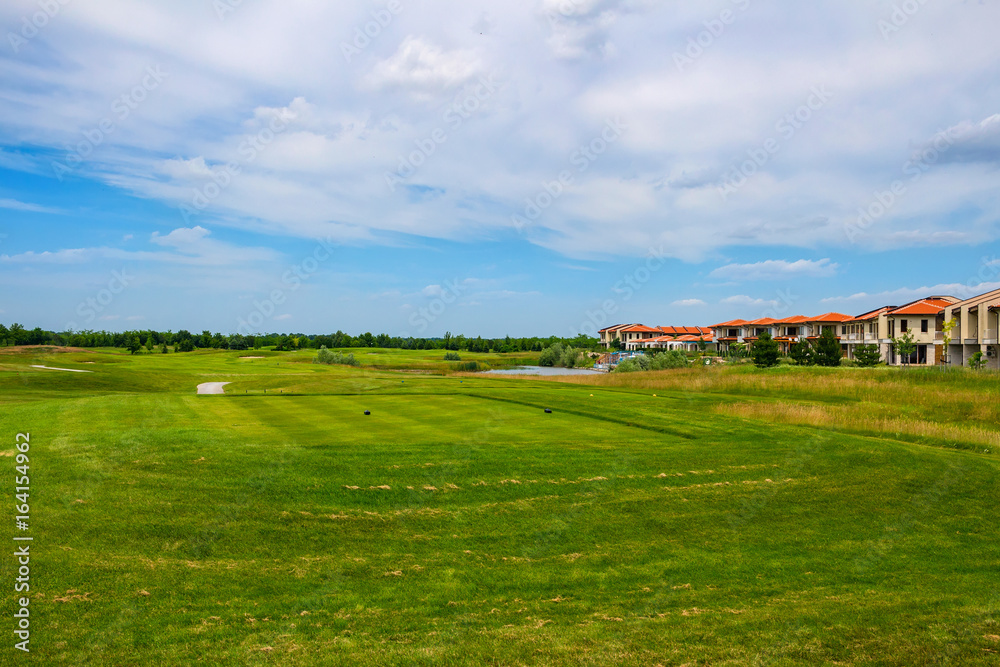 Green field for golf near apartment buildings, tranquil place for rest