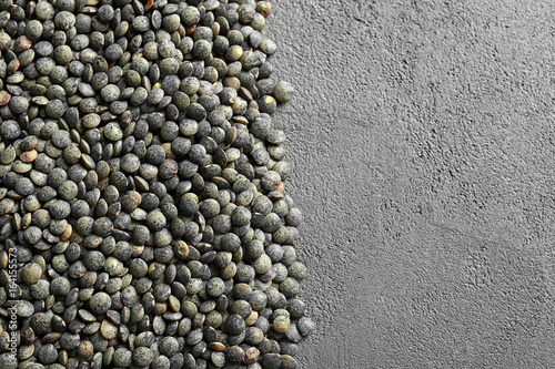 Heap of black lentils on grey background
