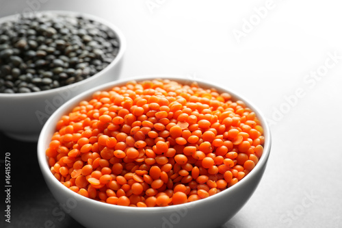 Bowls with red and black lentils on table