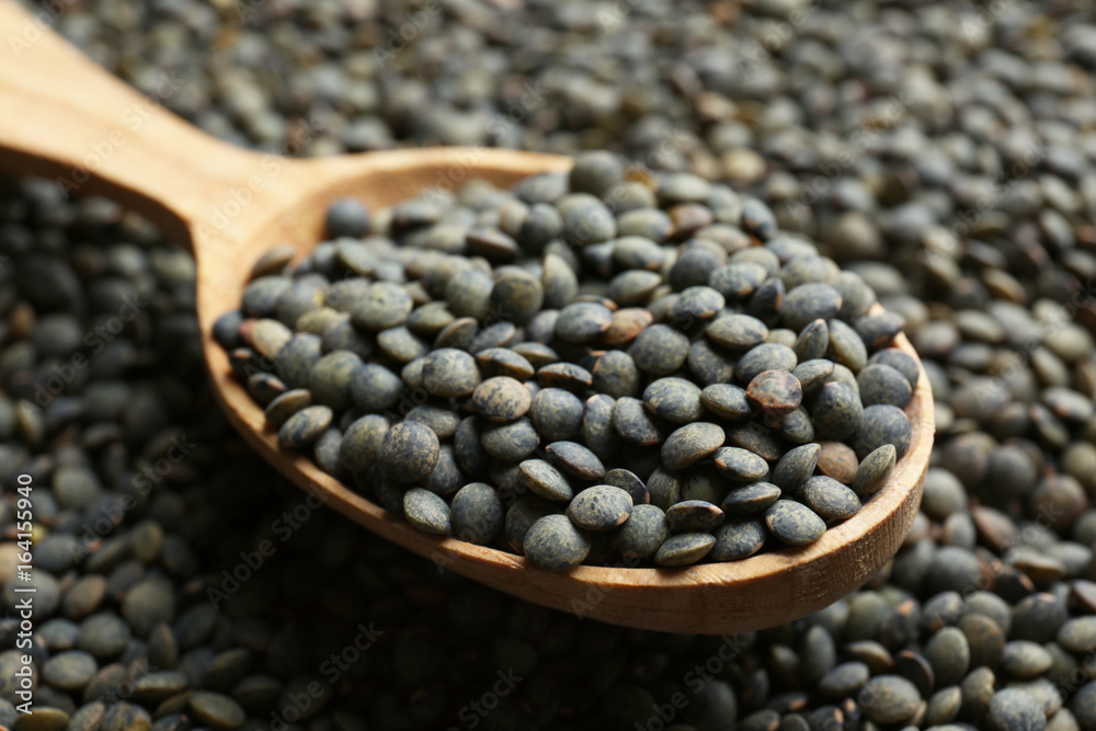 Wooden spoon with black lentils, closeup Wooden spoon with black lentils, closeup
