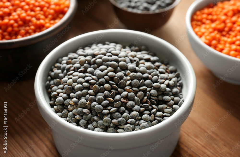 Bowls with red and black lentils on wooden background Bowls with red and black lentils on wooden background