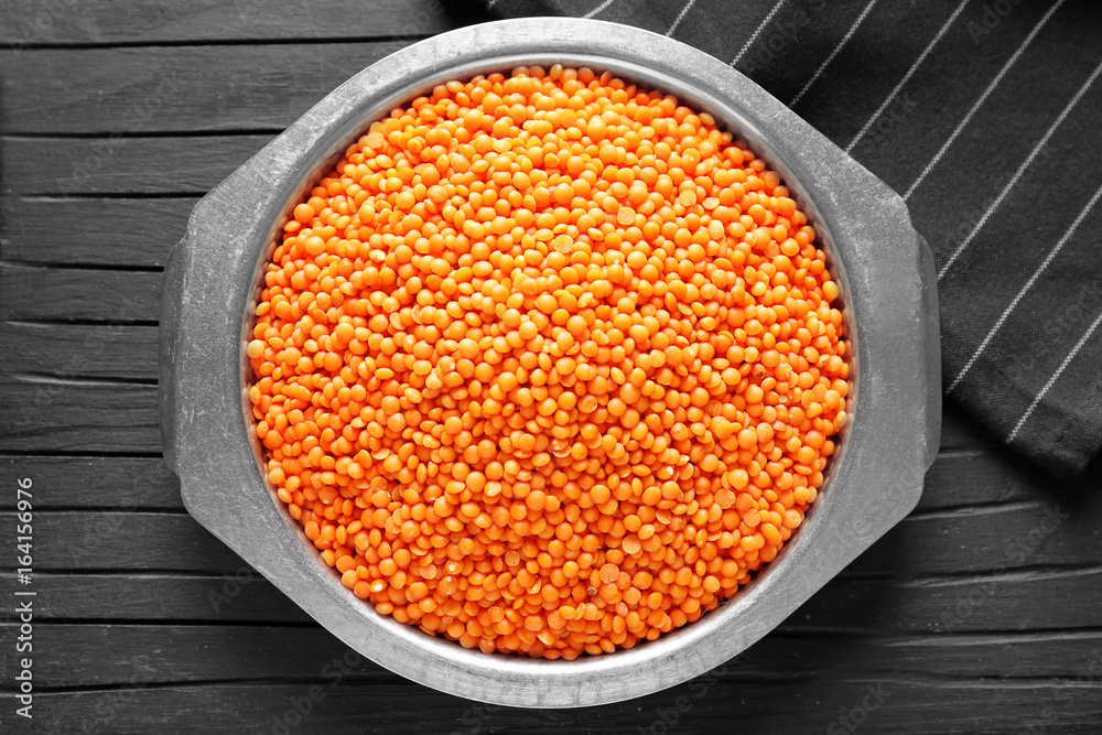 Plate with red lentils on wooden background Plate with red lentils on wooden background