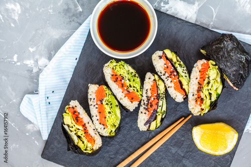 Healthy Japanese onigirazu with fish, brown rice and vegetables. photo