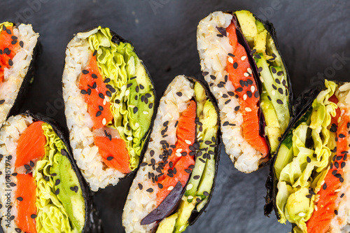 Healthy Japanese onigirazu with fish, brown rice and vegetables. photo