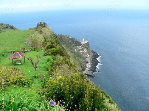 Blick vom Miradouro da Vista dos Barcos auf den Leuchtturm Farol do Arnel und Fischerhafen, Sao Miguel, Azoren, Portugal photo