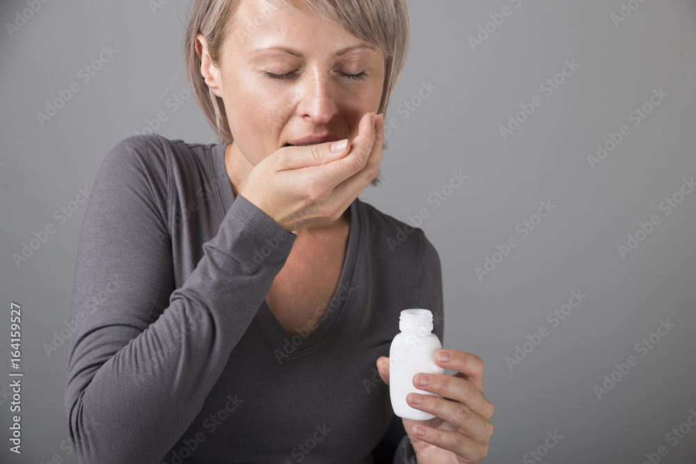 Beautiful lady holding a medicine pill in her hand Beautiful lady holding a medicine pill in her hand