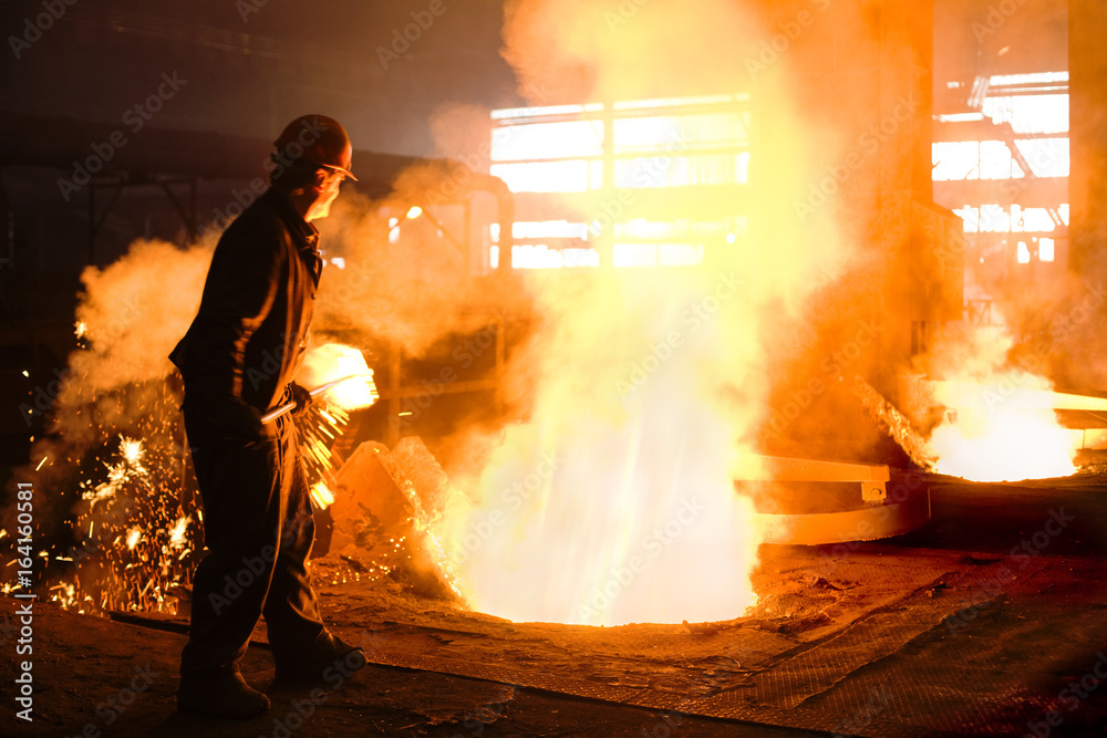 Worker working with a molten metal in the foundry Worker working with a molten metal in the foundry