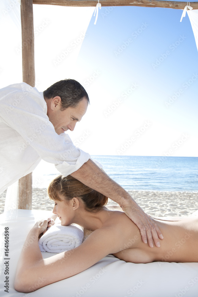 homme qui masse une femme torse nu sur la plage Stock Photo | Adobe Stock