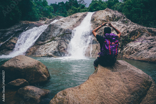 Man sitting in front waterfall in pahang,malaysia