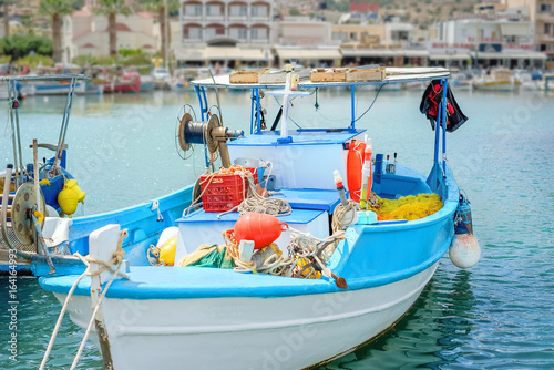 White-blue fishing boat moored in Agios Nicolaos harbor in Crete photo