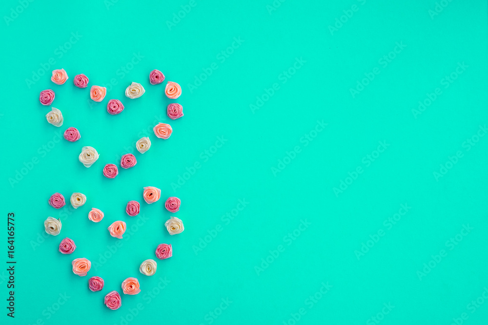 Love symbol. Heart symbol made with multicolored ribbon roses on textured paper background. Template for greeting card, postcard, advertising design. Space for text. Love symbol. Heart symbol made with multicolored ribbon roses on textured paper background. Template for greeting card, postcard, advertising design. Space for text.