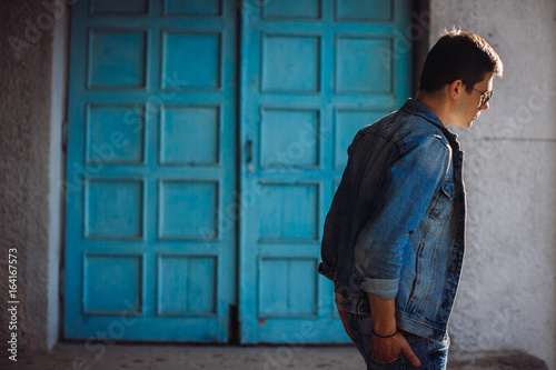 Man dressed in casual style walks outside