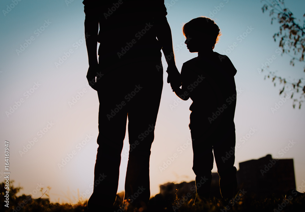 silhouette of father and son holding hands at sunset silhouette of father and son holding hands at sunset