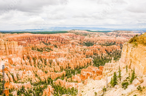 Hoodoos with pine trees and storm clouds at Bryce Canyon National Park in Utah.