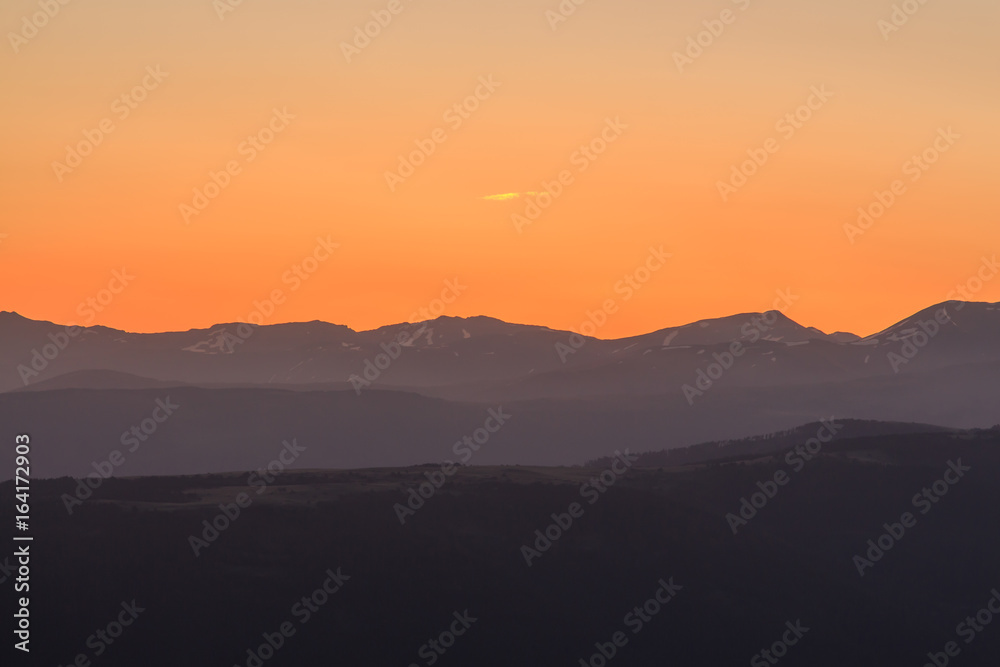 Orange sunrise with mountains. Atmospheric phenomena concept