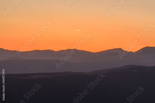 Orange sunrise with mountains. Atmospheric phenomena concept © Rafa