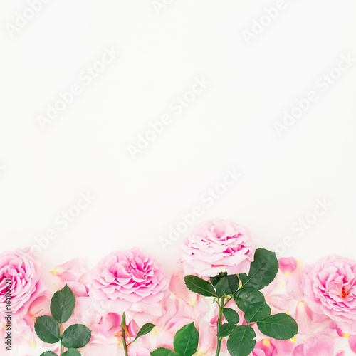 Floral pattern of pink roses on white background. Flat lay, top view. Floral frame © artifirsov