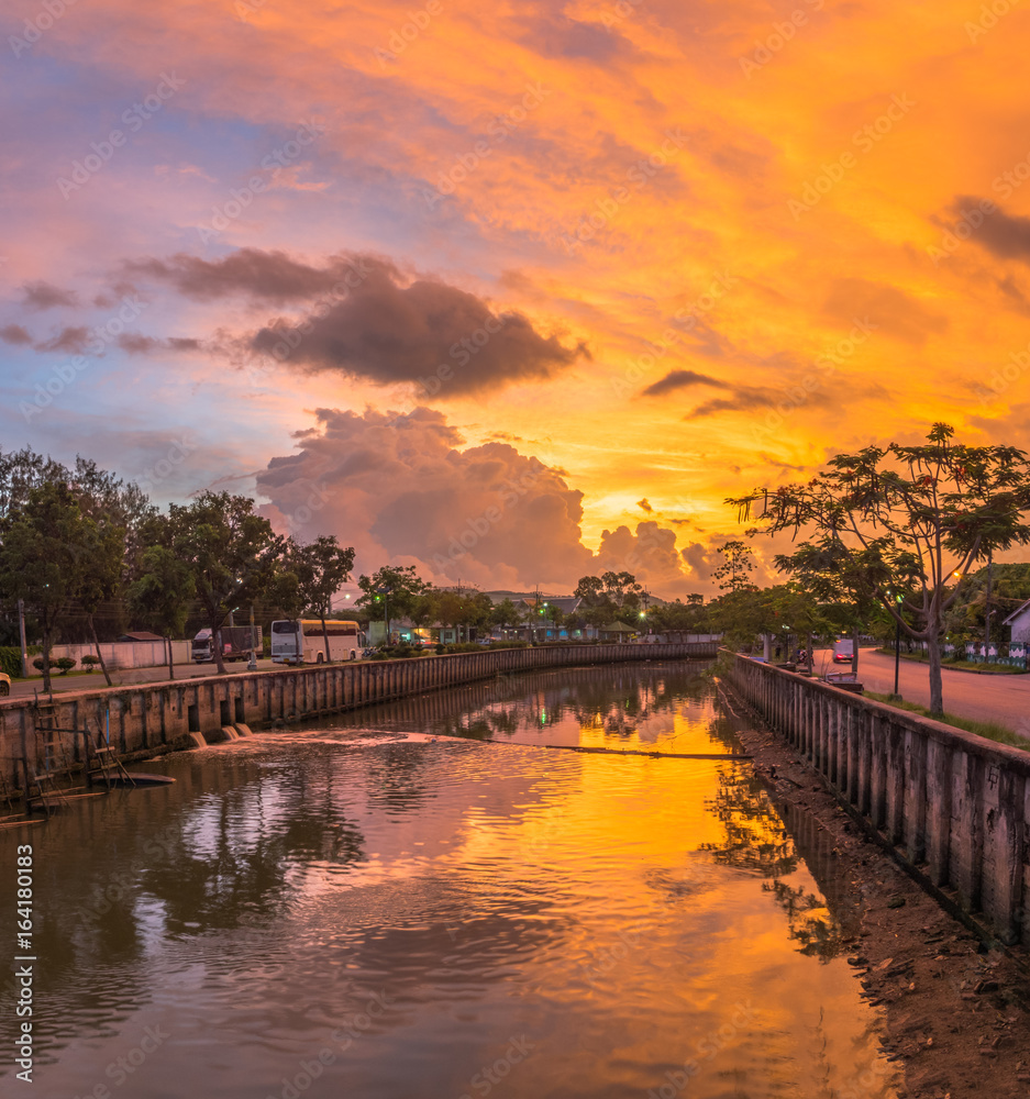 bright orange sky above canal.bright color on sky reflection with water in canal from Phuket city flow into the ocean.