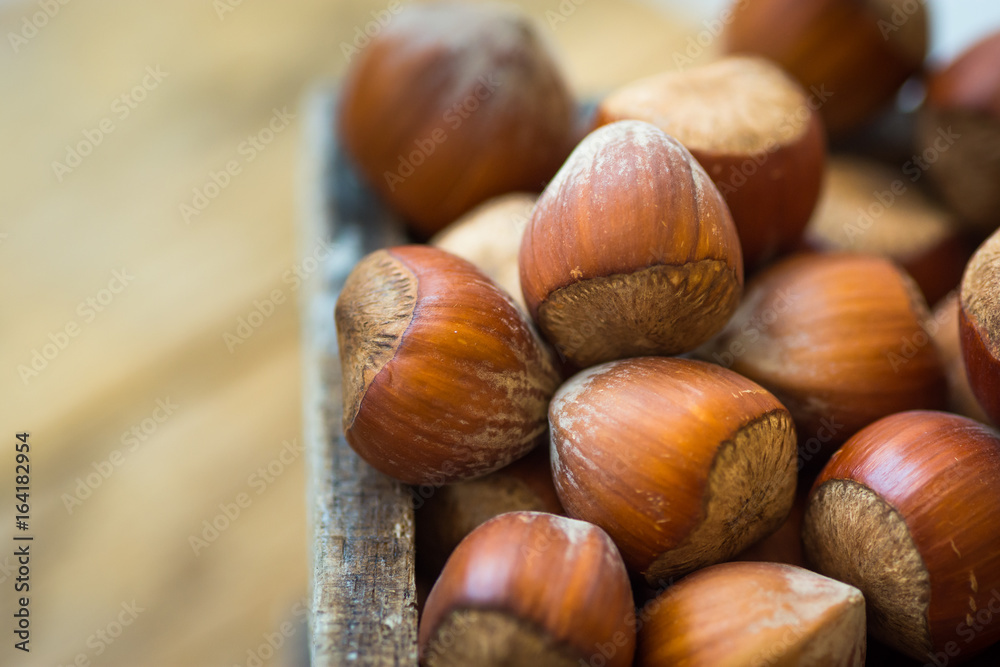 Pile of whole hazelnuts in wood box on garden table, close up, vibrant color, top view view, cozy autumn atmosphere, inspirational Pile of whole hazelnuts in wood box on garden table, close up, vibrant color, top view view, cozy autumn atmosphere, inspirational