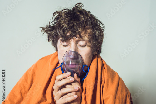 man with flu or cold symptoms making inhalation with nebulizer - medical inhalation therapy photo