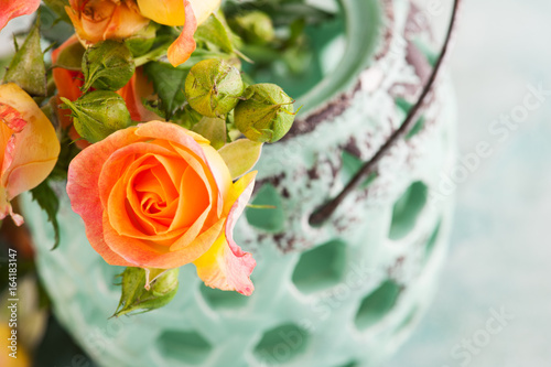 Fresh orange roses flowers in mint vase