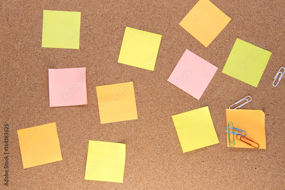 Fototapeta premium Multiple multi-coloured post it notes on a wooden background 