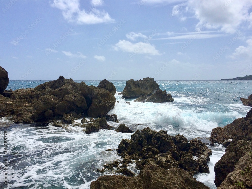 Secret tropical romantic cove: Rocks, wild waves & crystal clear blue water ocean in Boston Bay Jamaica in the Portland Parish (Caribbean island)
