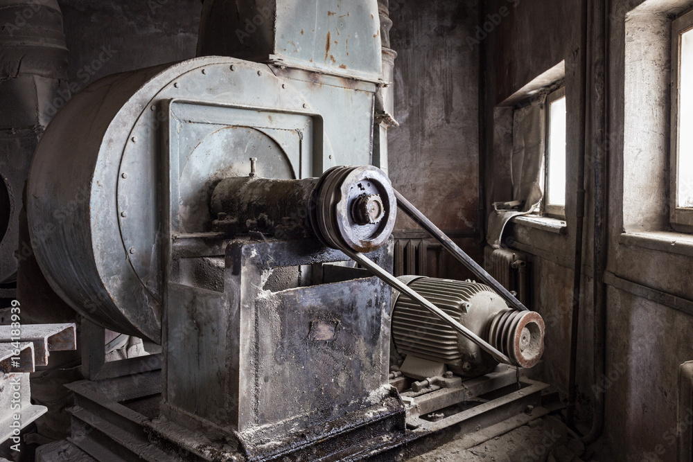 Old mechanisms covered with a thick layer of dust in an abandoned factory