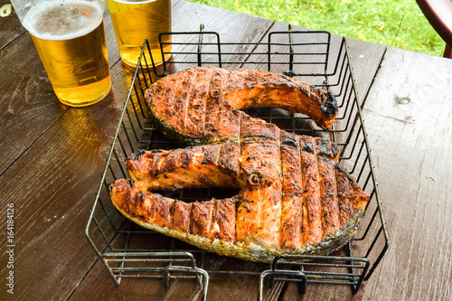 Grilled salmon steak. Two glasses with beer. Picnic in nature photo