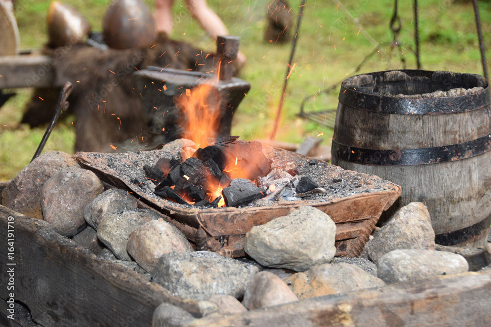 Blacksmith when working with a hammer in the open air Blacksmith when working with a hammer in the open air