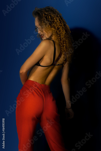 Gorgeous lady with curly hait in red pants