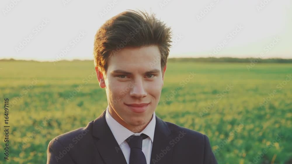 Portrait of happy businessman smiling at camera on evening field's background Portrait of happy businessman smiling at camera on evening field's background
