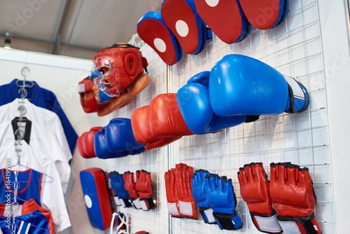 Boxing gloves, helmets and shoes for martial arts in shop photo