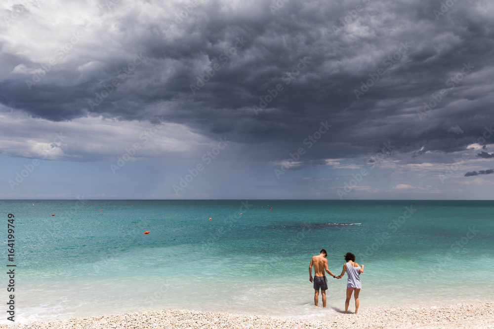 Young couple in the water on a desert beach