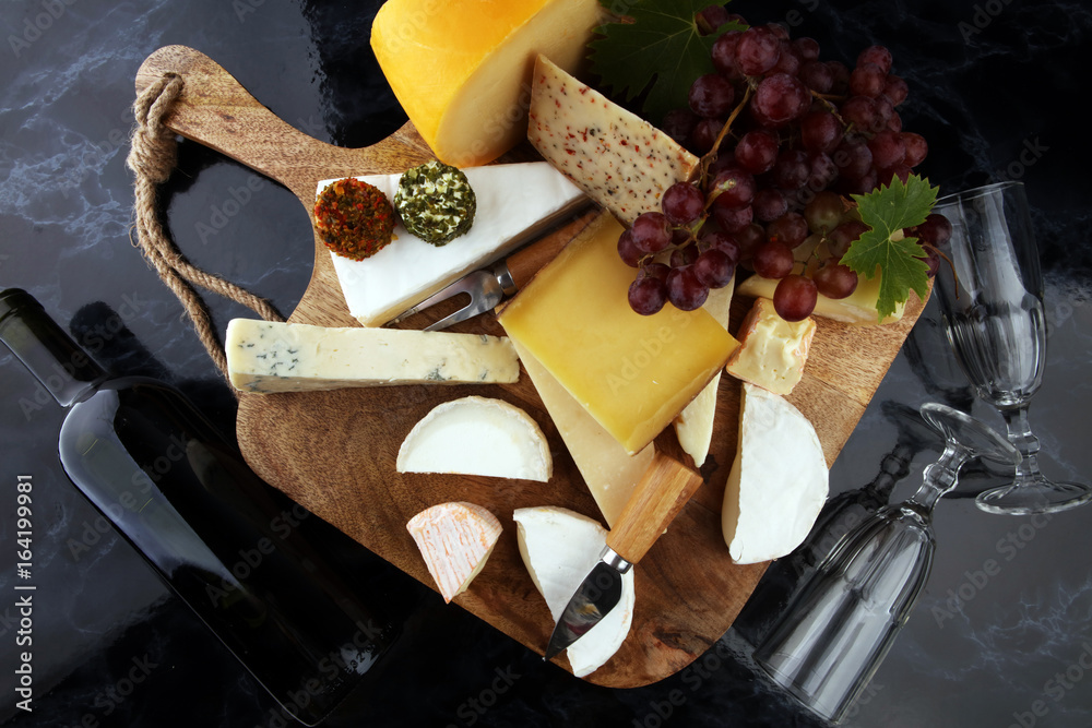 Fototapeta premium Cheese platter with different cheese and grapes