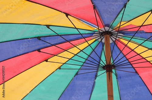 beach sun parasol umbrella in rainbow colours background with copy space on umbrella photo