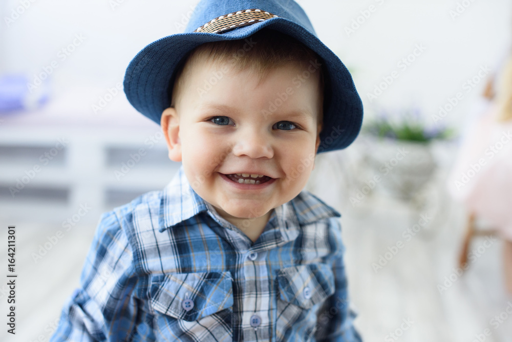 Happy smiling little child boy in a blue hat