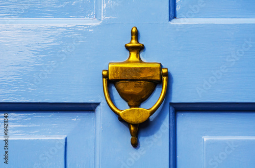 Door with brass knocker in the shape of a hand, beautiful entrance to the house photo