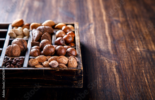 Nuts Mixed in a Wooden Vintage Box.Assortment, Walnuts,Pecan,Peanuts,Almonds,Hazelnuts,Macadamia,Cashews,Pistachios.Concept of Healthy Eating.Vegetarian.Copy space.selective focus.
