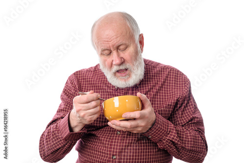 Senior man eating from oragne bowl, isolated on white