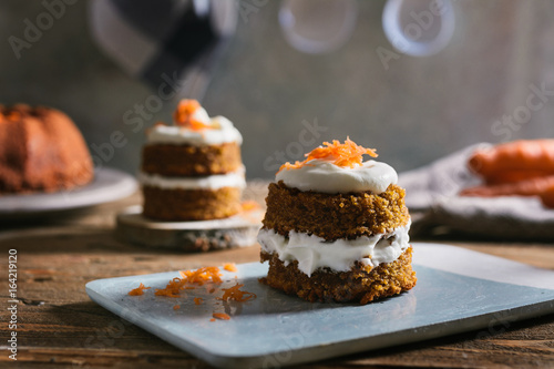 Mini carrot cake, stuffed with cream cheese, on blue concrete dish photo
