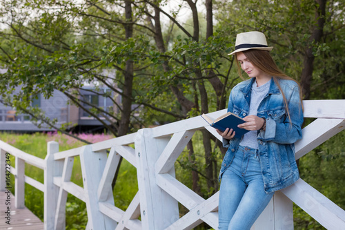 Teen woman read book outside