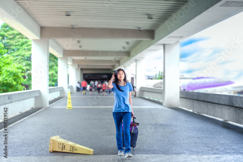 Teen girl walking with luggage at airport terminal