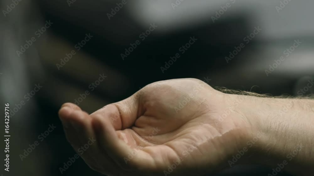 Rain is dropping on a man's hand. It is a first rain in this year. Wet smell of rain. slowmotion Rain is dropping on a man's hand. It is a first rain in this year. Wet smell of rain. slowmotion