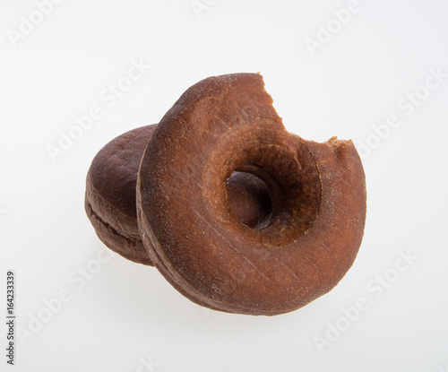 donut or donut with missing bite on a background. © heinteh