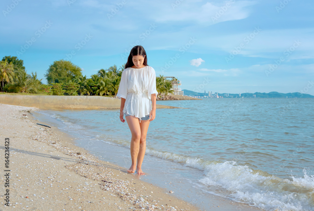 Young woman walking along the beach