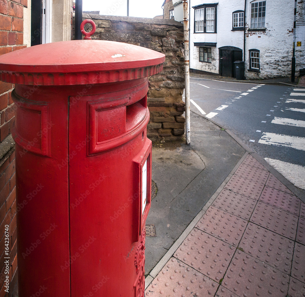 A classic British red postbox near a zebra crossing in a village in Herefordshire, UK A classic British red postbox near a zebra crossing in a village in Herefordshire, UK