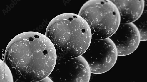 Seamlessly looping pan over an endless line of black and white bowling balls on a reflective surface. This video is a 3d render.
