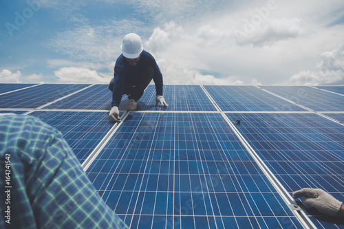 engineer or electrician working on replacement solar panel at solar power plant; working on repair solar panel to swap panel
